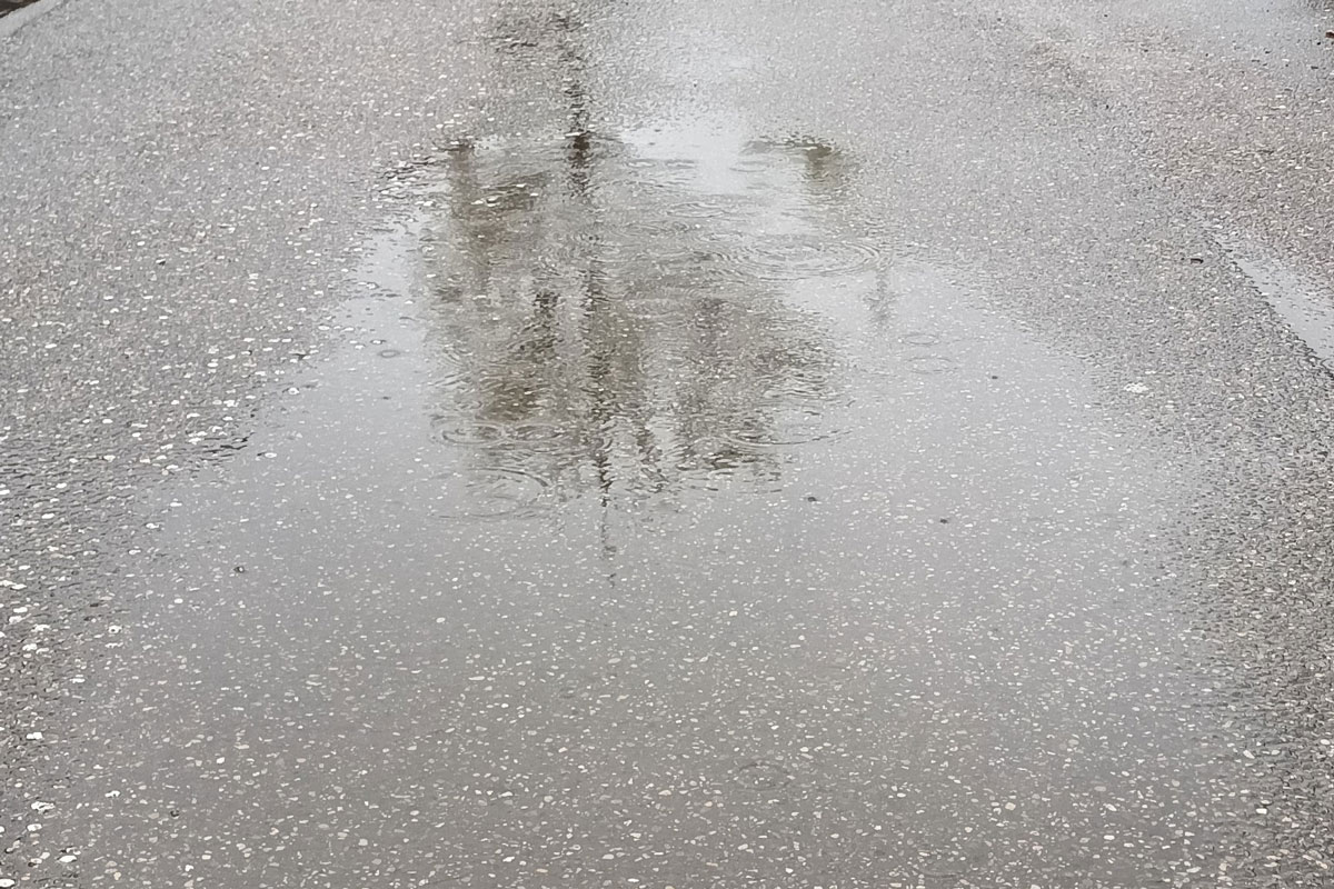 Eine Pfütze auf einer asphaltierten Straße